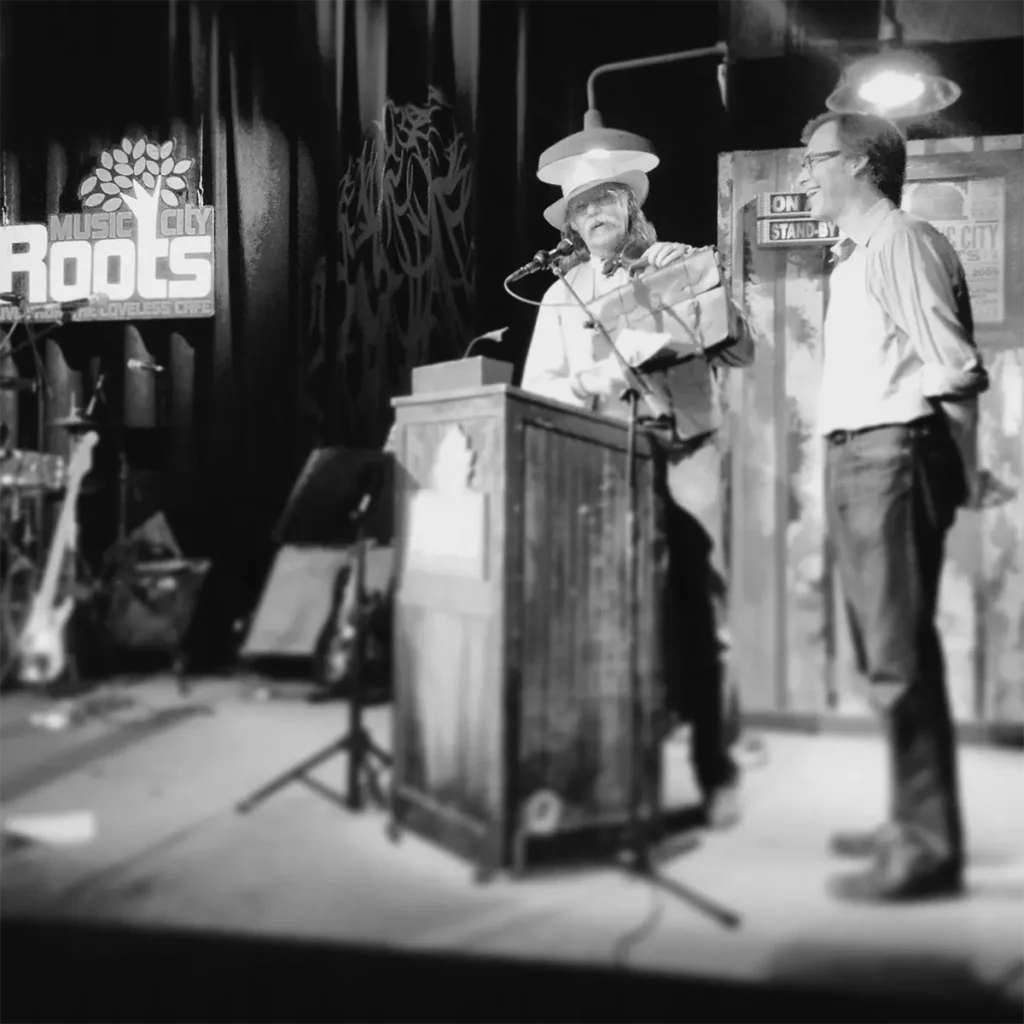 colonel presenting leather product on stage of music city roots