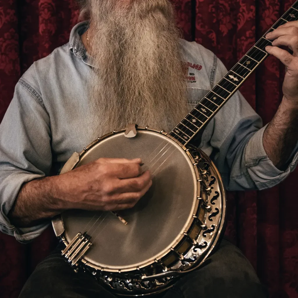 man playing banjo photo by tim-mossholder