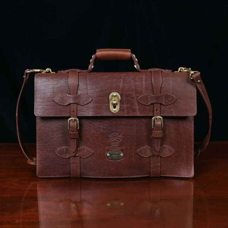 1943 Navigator Briefcase in Vintage Brown Steerhide - front view - on a wood table with a dark background