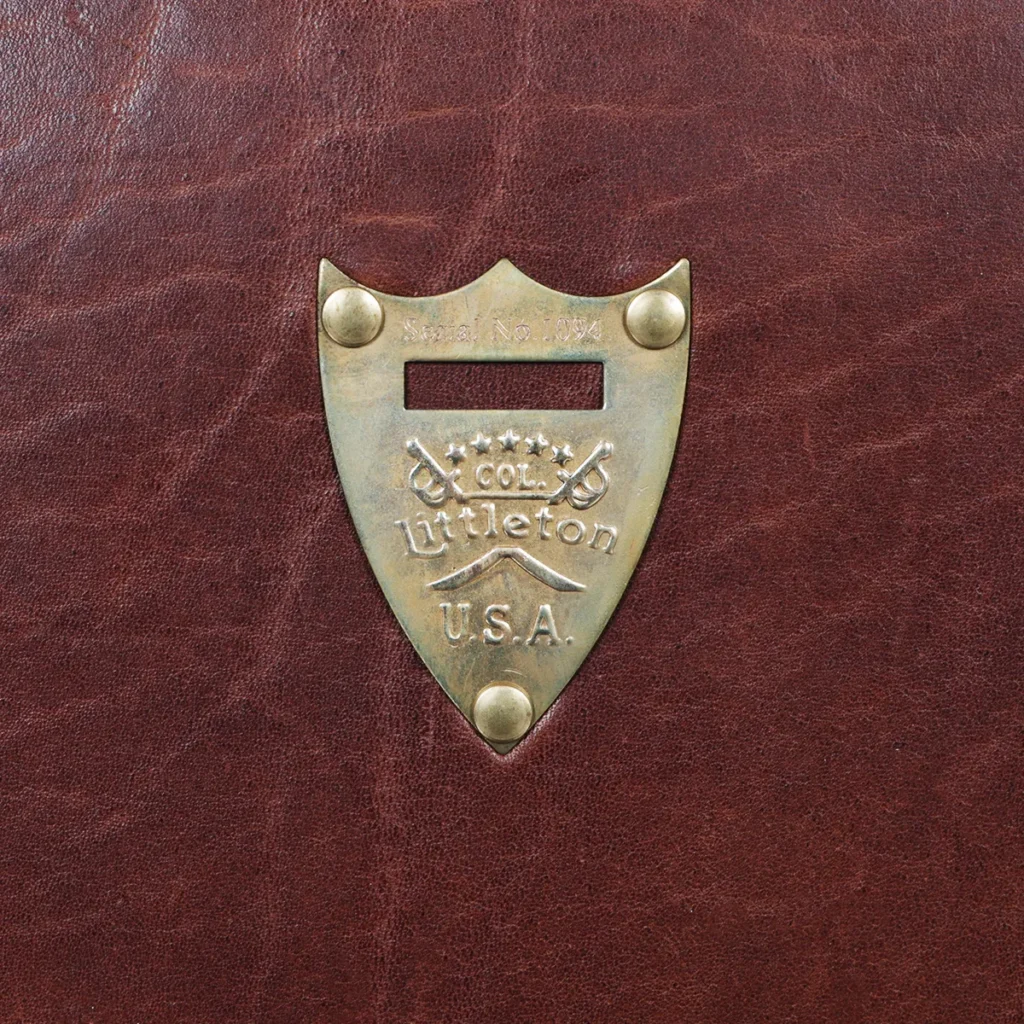 History of the Navigator Briefcase 3 1943 Navigator Briefcase in Vintage Brown Steerhide - pommel view - on a wood table with a dark background