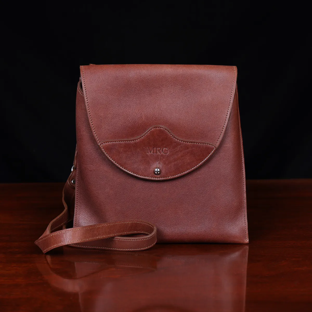 No. 22B Derby Handbag in Vintage Brown on a wood table with a dark background - front view