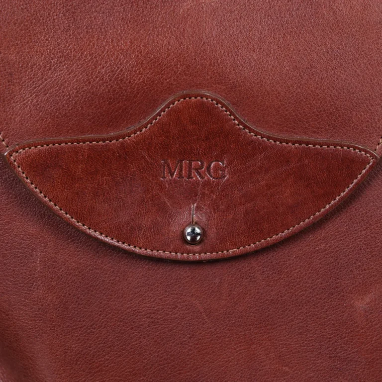 No. 22B Derby Handbag in Vintage Brown on a wood table with a dark background - front view of initials