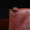 No. 22B Derby Handbag in Vintage Brown on a wood table with a dark background - detail view