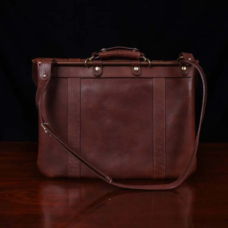 no 16 brown vintage leather document bag with strap on a wooden table with a dark background - back view