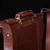 no 16 brown vintage leather document bag with strap on a wooden table with a dark background - view of handle