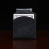 black leather front pocket wallet on wood shelf with money
