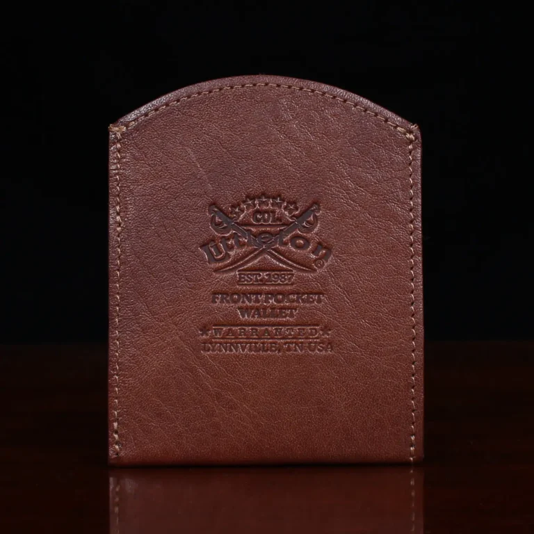brown leather front pocket wallet on wood shelf back