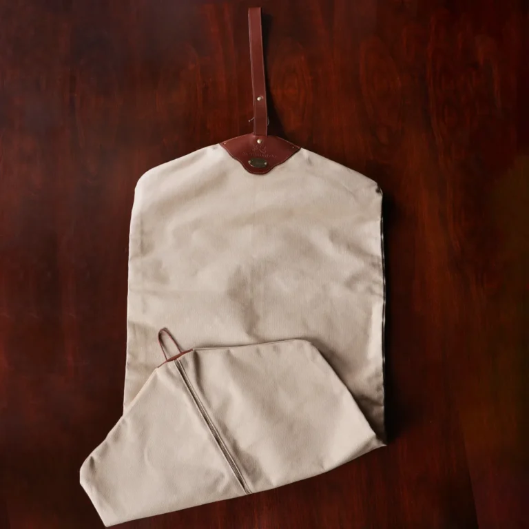 no7 khaki cotton canvas garment bag with brown leather strap full back view on wooden table