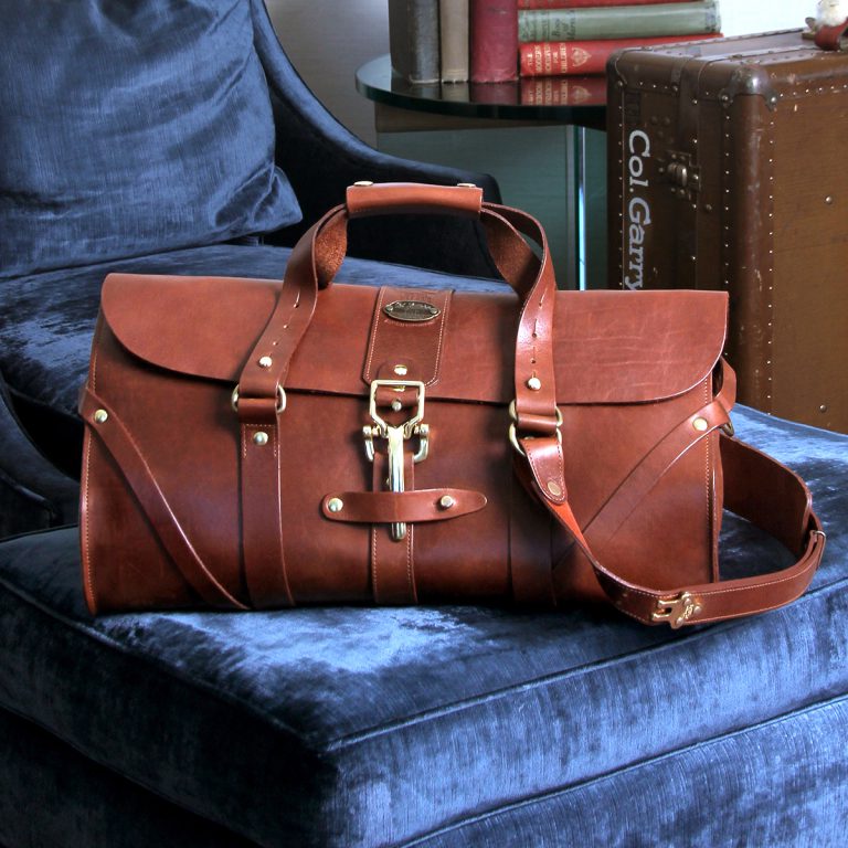leather travel duffle bag on blue chair