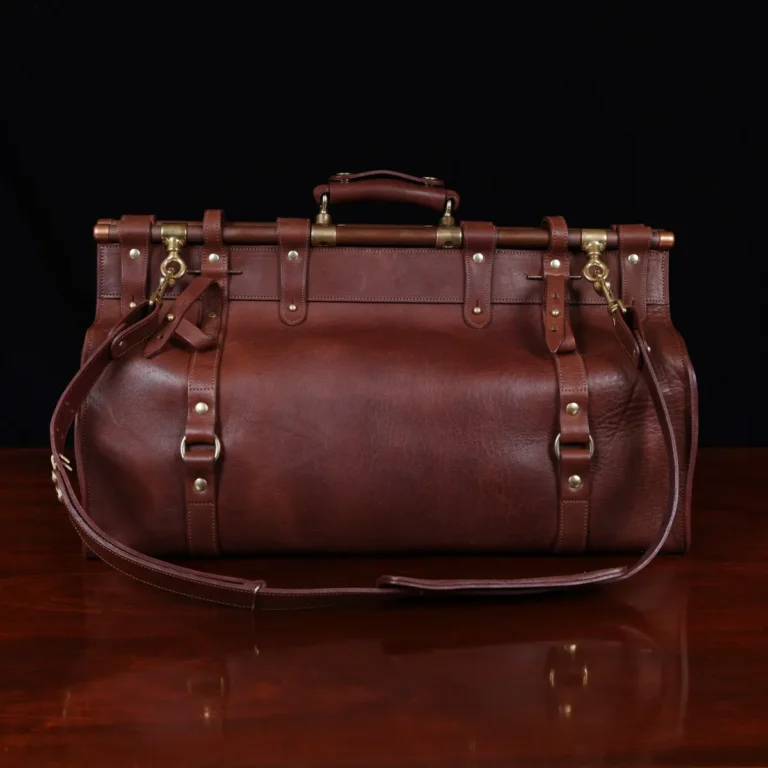Vintage-style dark brown No. 3 Grip Bag on wooden table with a dark background - back view