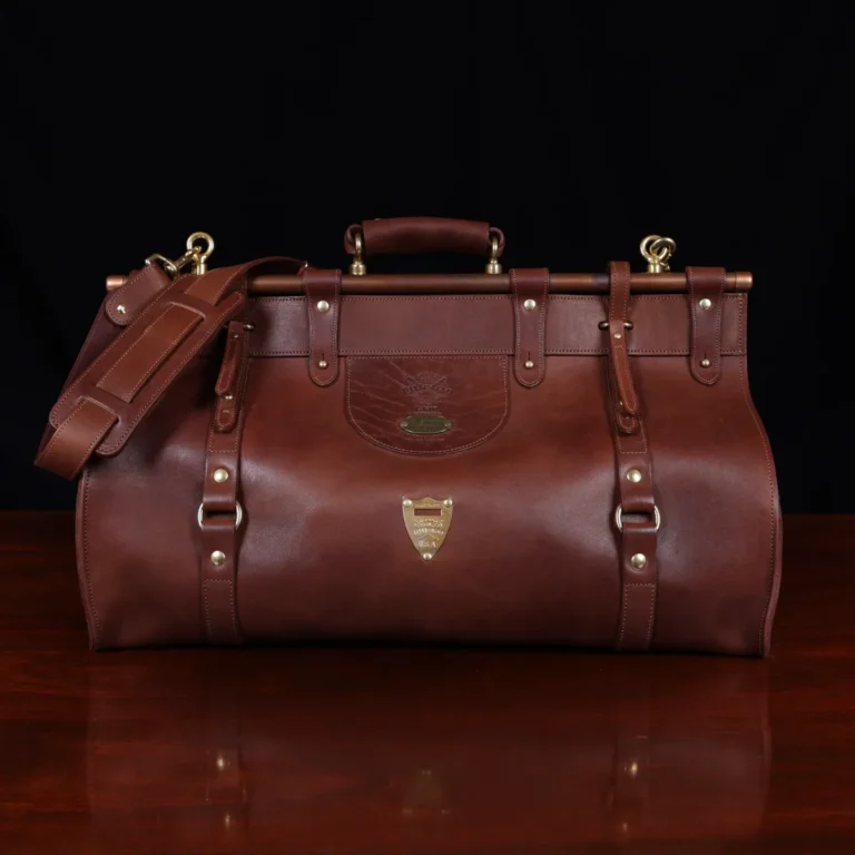Vintage-style dark brown No. 3 Grip Bag on wooden table with a dark background - front view