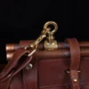 Vintage-style dark brown No. 3 Grip Bag on wooden table with a dark background - view of hook