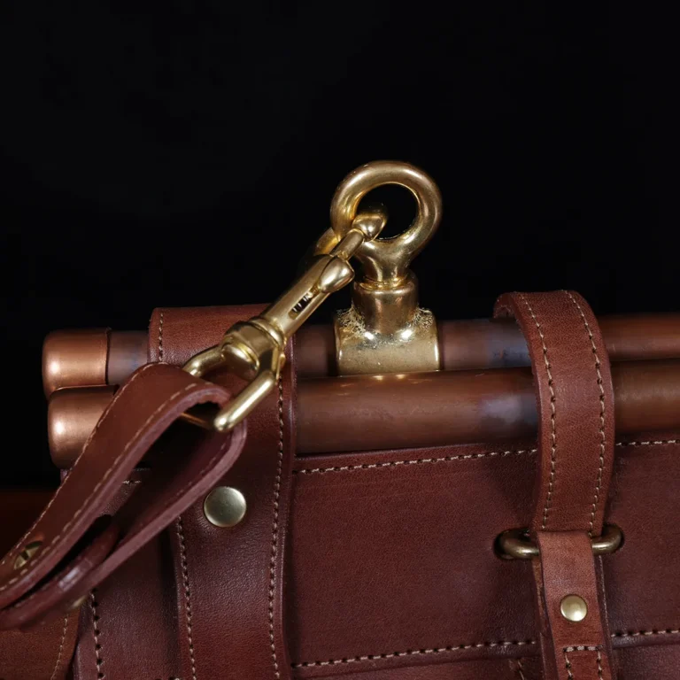 Vintage-style dark brown No. 3 Grip Bag on wooden table with a dark background - view of hook