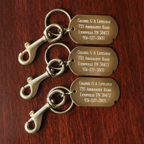 brass id luggage tags with personalization on a wooden table