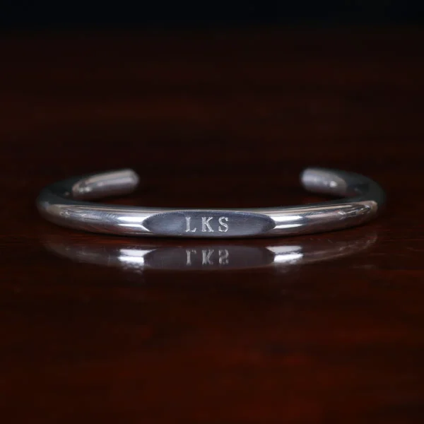 pewter engravable wristwire bracelet on wooden table - front view