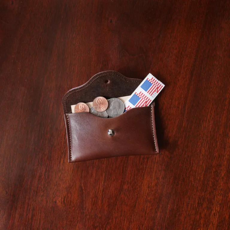 no15 vintage brown american leather pouch on a wooden table with stamps and coins