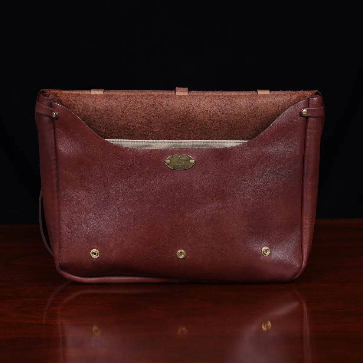 No. 1 Saddlebag Briefcase on a wooden table with a dark background - front open view