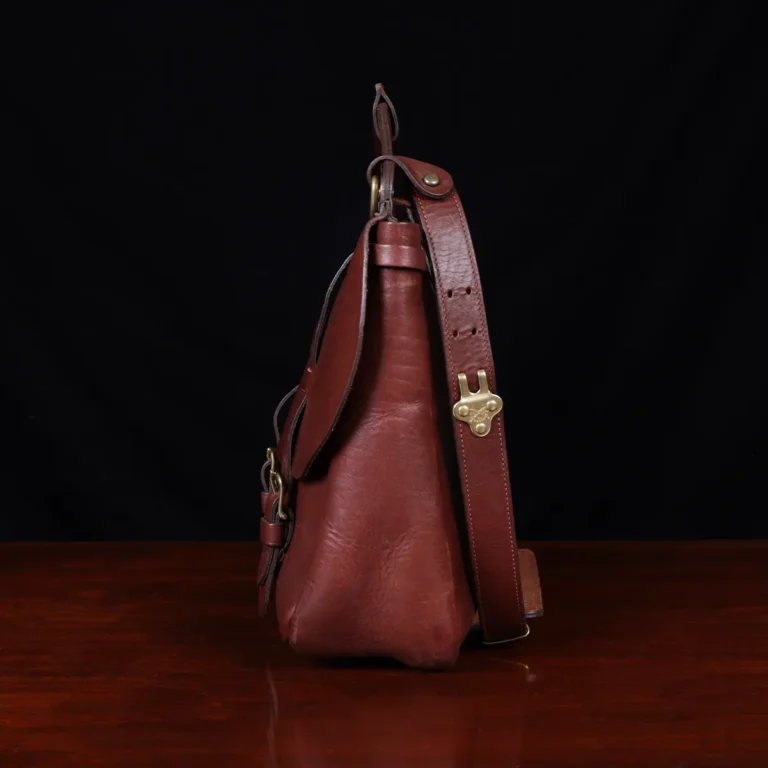No. 1 Saddlebag Briefcase on a wooden table with a dark background - left side view