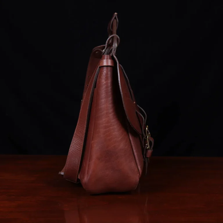 No. 1 Saddlebag Briefcase on a wooden table with a dark background - right side view