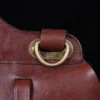 No. 1 Saddlebag Briefcase on a wooden table with a dark background - strap view