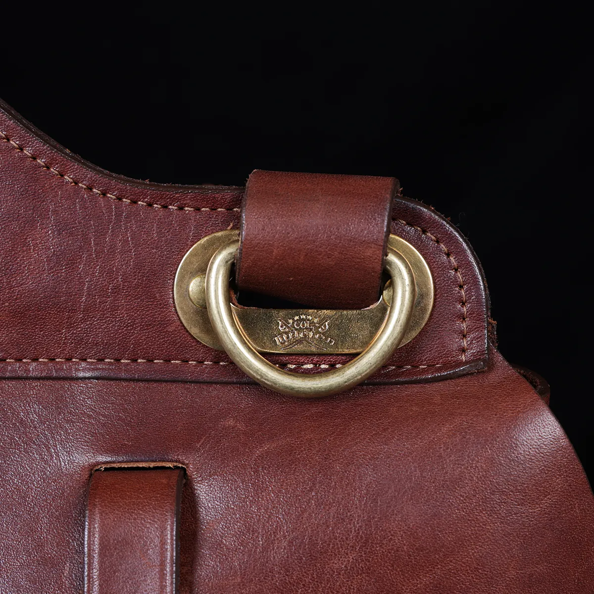 No. 1 Saddlebag Briefcase on a wooden table with a dark background - strap view