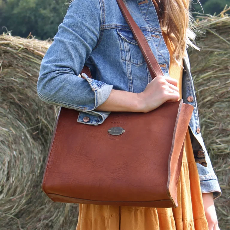 women in a hay field wearing a wayfarer tote