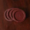 brown round leather coaster set on wooden table