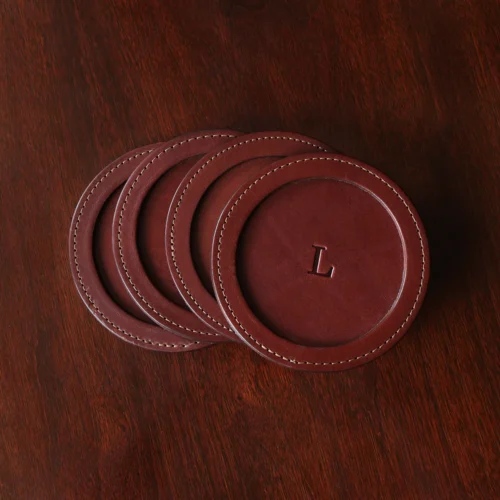 brown round leather coaster set on wooden table