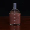 Cologne bottle sitting on wooden table back view