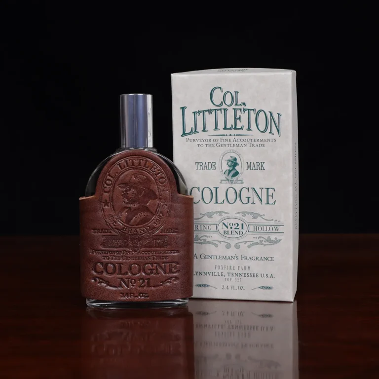 Cologne bottle sitting on wooden table front view with lid and gift box