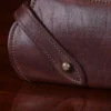 Brown leather No. 2 Eyeglass Case on top of a wooden table with a dark background - latch