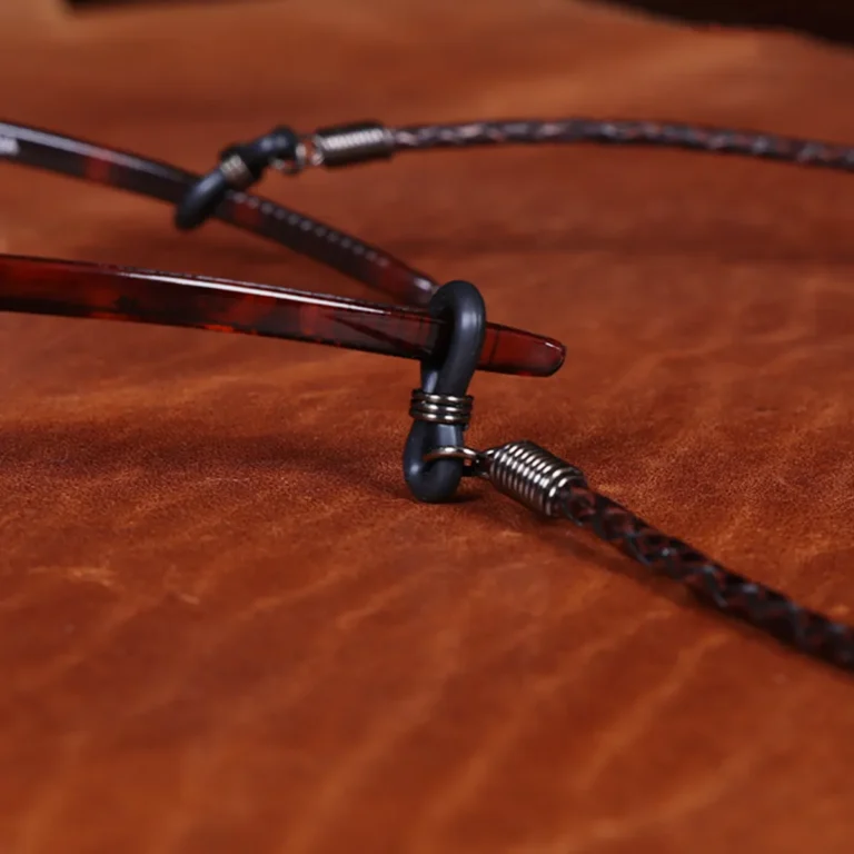 leather eyeglass lanyard in dark brown braided style on light colored leather