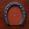 leather horseshoe coaster with personalization initial stamp on wooden table