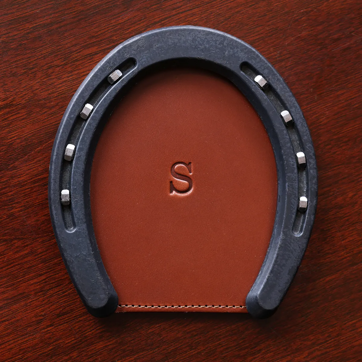 leather horseshoe coaster with personalization initial stamp on wooden table
