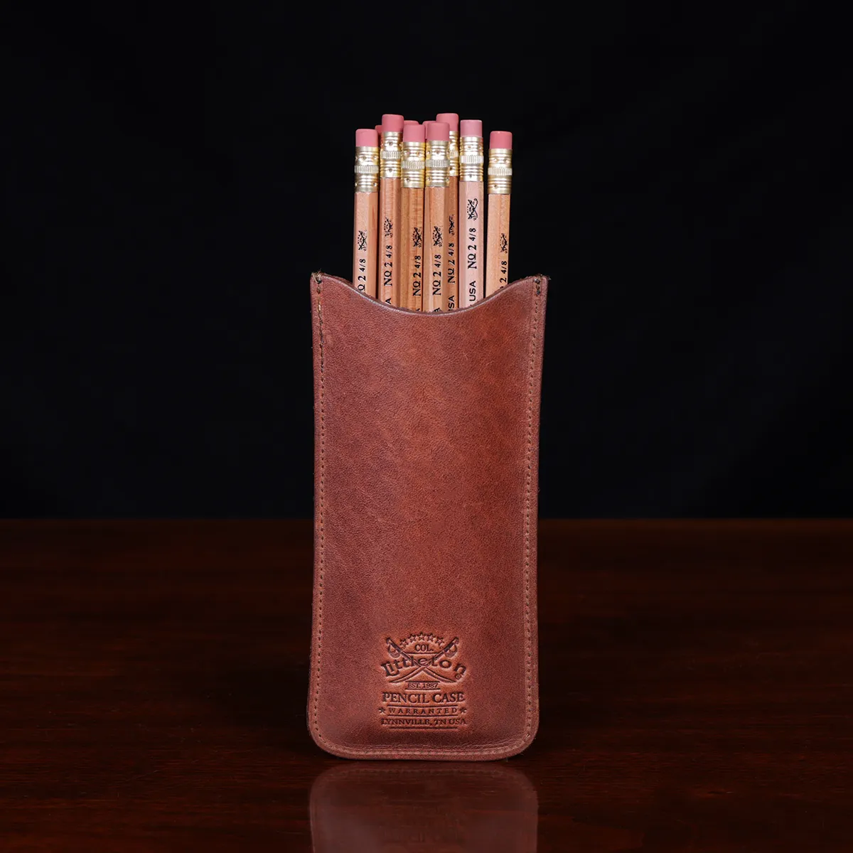 leather pencil case on wooden table with 12 pencils - back view