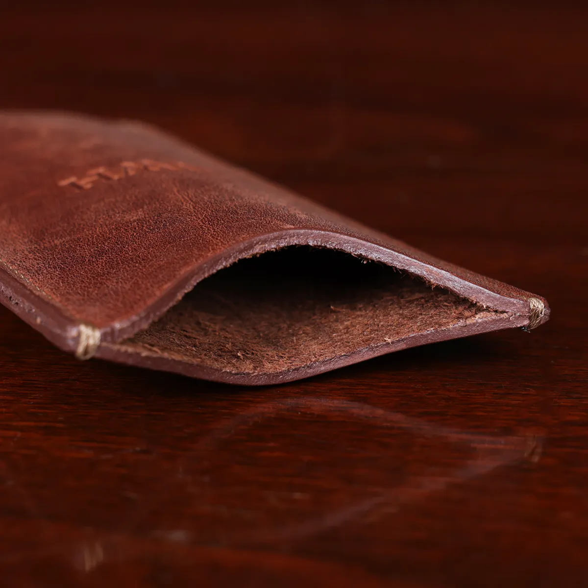 leather pencil case open on wooden table