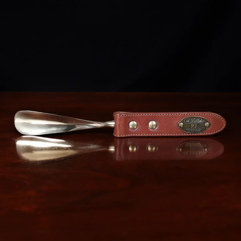 no2 shoehorn with personalization plate on a wooden table with a dark background