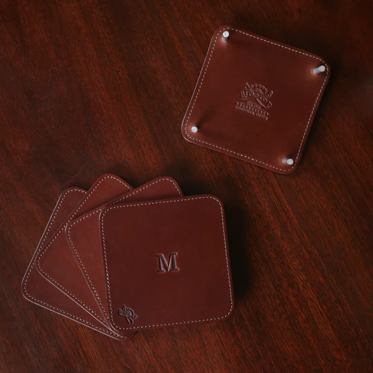 brown square leather coaster set and holder on wooden table