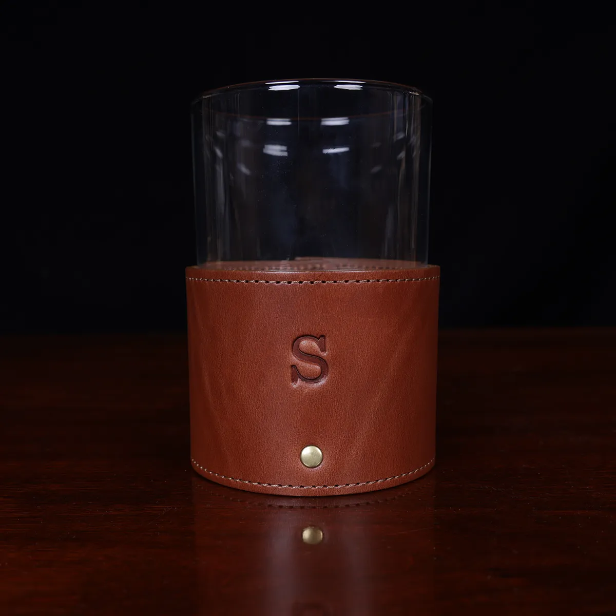 leather veranda glass sleeve and glass on wooden table with dark background