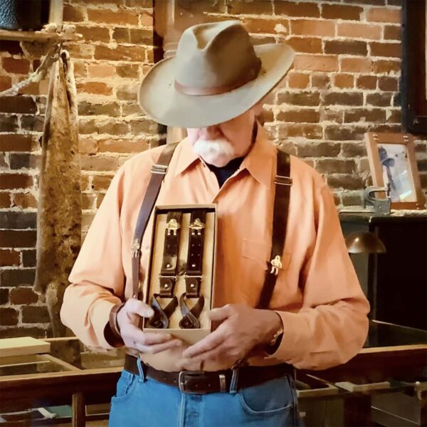 colonel littleton holding gift box containing tobacco brown american buffalo suspenders