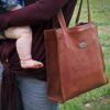 Woman carrying Leather vintage brown tote and baby