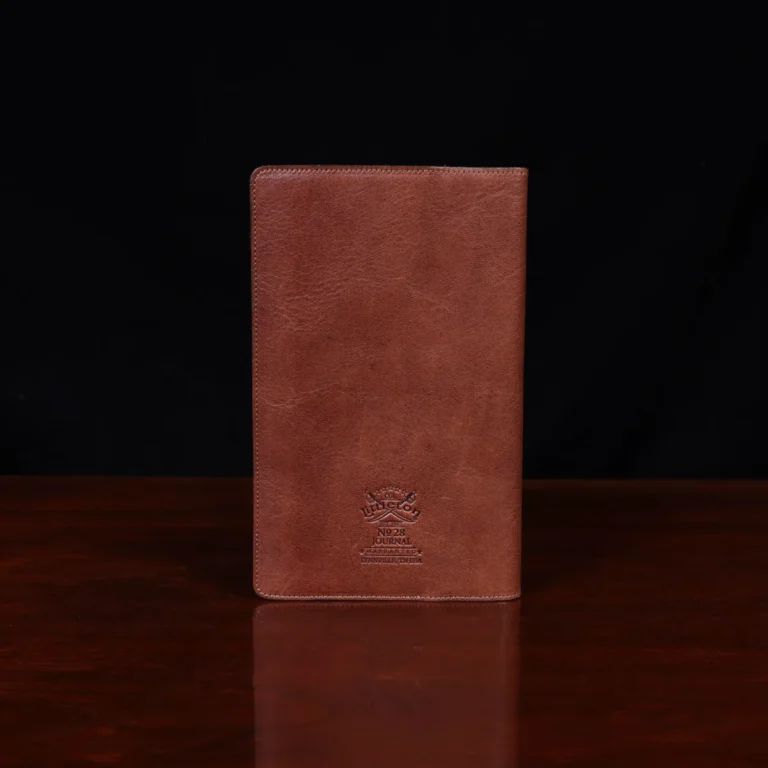 no 28 leather pocket journal on a wooden table with a dark background - back view