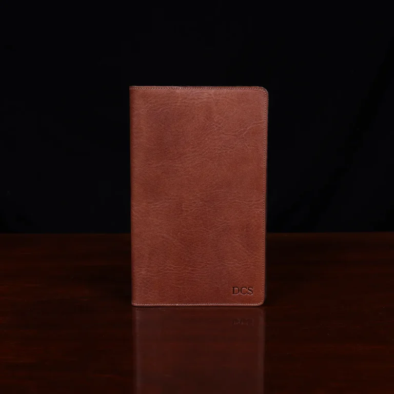 no 28 leather pocket journal on a wooden table with a dark background - fron view