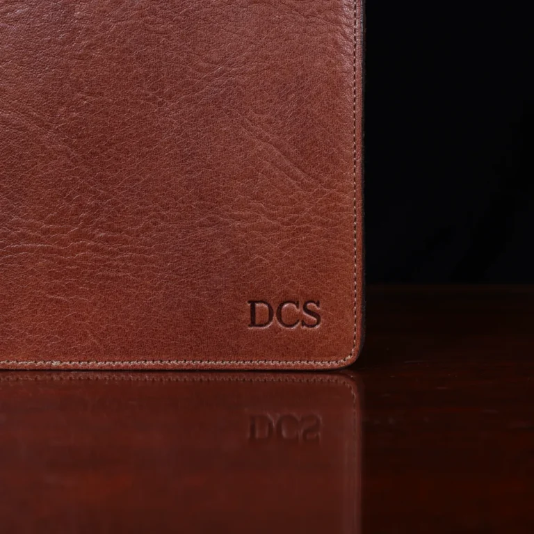no 28 leather pocket journal on a wooden table with a dark background - front view of personalization