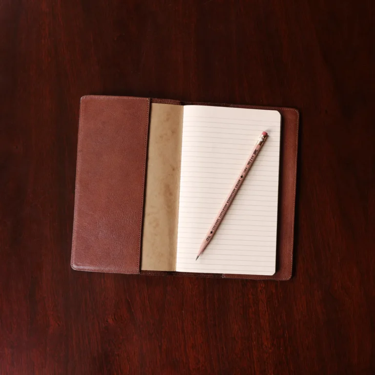 no 28 leather pocket journal on a wooden table with a dark background - open front view