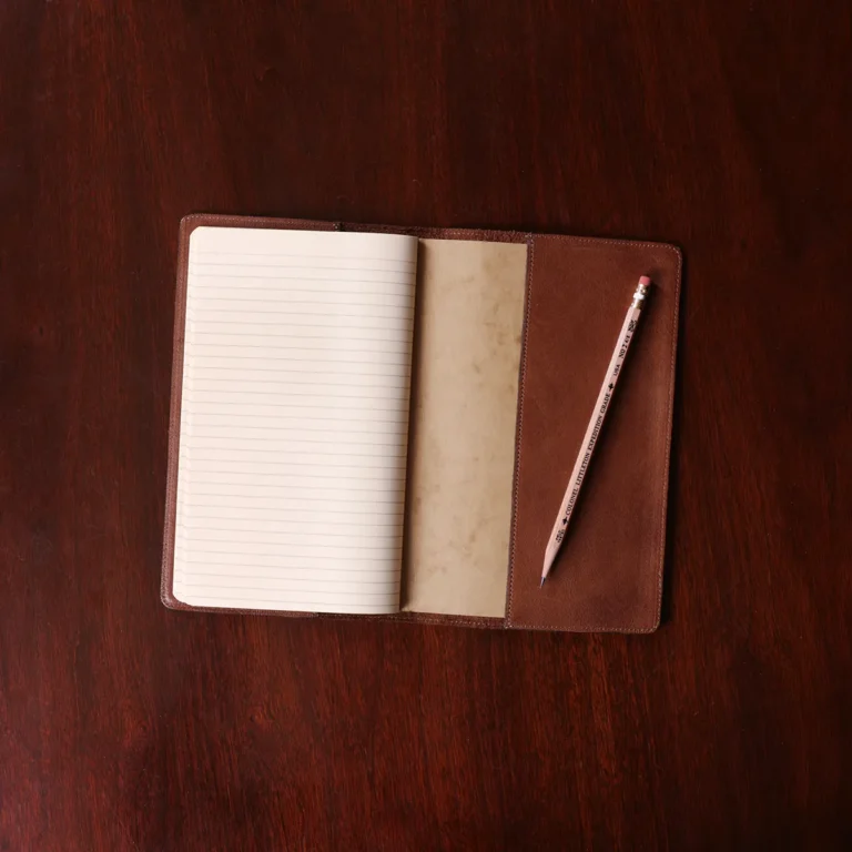 no 28 leather pocket journal on a wooden table with a dark background - open back view