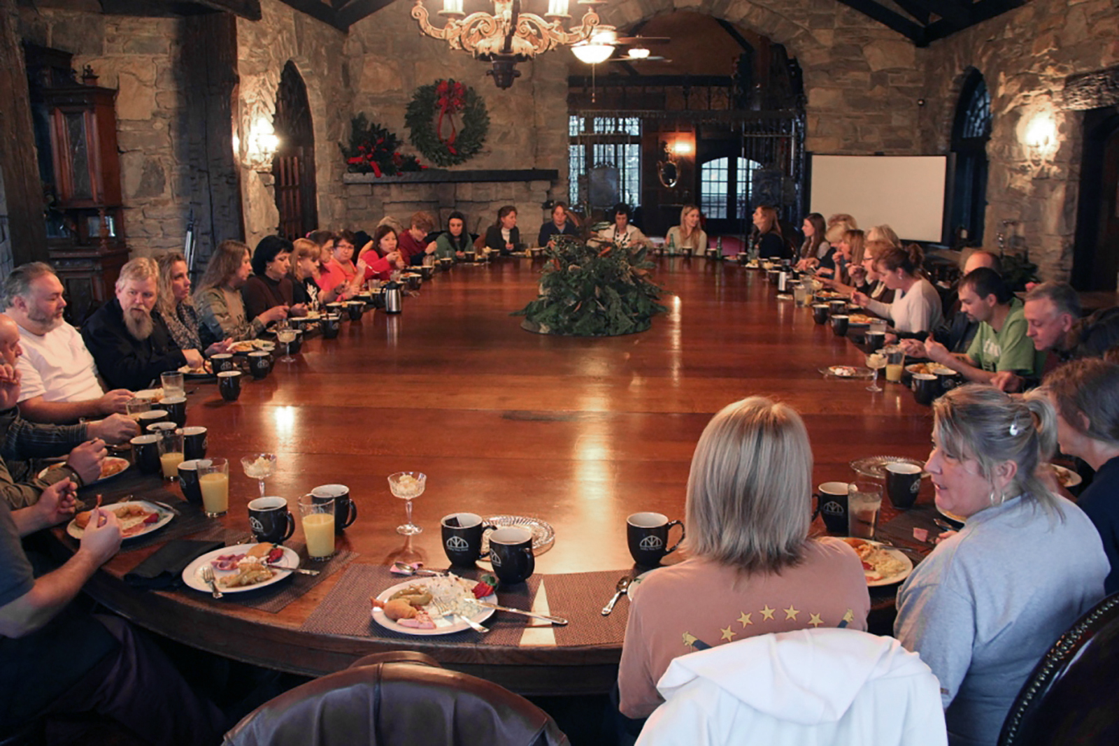 Colonel Littleton staff seated at the large dining room table eating breakfast at the Milky Way Farm.