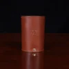vintage brown steerhide leather can caddy with initial stamp on wooden table with dark background - front view