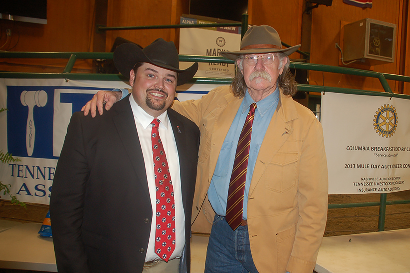 Colonel Littleton standing to the right of Junior Staggs with an arm around Junior's shoulder as both stand smiling into the camera