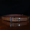 An American Alligator Belt with Nickel hardware showing the front view on a wooden table with black background - id 001